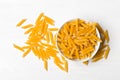 Heap of dried, raw, uncooked penne pasta in bowl on table Royalty Free Stock Photo