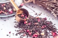 Heap of dry black tea with vanilla, cranberries, rose petals, pineapple on a wooden surface. Measuring Spoon For Tea