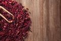 Heap of dry hibiscus tea with scoop on wooden background Royalty Free Stock Photo
