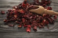 Heap of dry hibiscus tea with wooden scoop on table Royalty Free Stock Photo