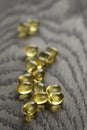 Heap of fish oil omega capsules on wooden table