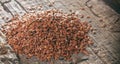 Heap of flax seeds, on wooden surface.