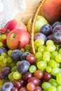 Heap of fresh fruits from new harvest poured out from wicker basket on wooden table with copy space. Royalty Free Stock Photo