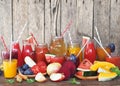 Heap of fresh fruits and fresh prepared cocktails of different colors on a wooden table.Rustic style.