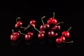 Heap of fresh fused cherry berries cherries on a dark background with reflection. Concept - Eating ugly fruits and vegetables.