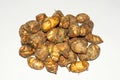 Fresh harvested organic taro corms,satoimo potatoes or taro roots on white background