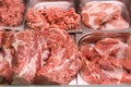 Heap of fresh meat food meat food background in supermarket store. Different types of raw meat in plastic boxes, leg of Royalty Free Stock Photo