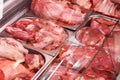 Heap of fresh meat food meat food background in supermarket store. Different types of raw meat in plastic boxes, leg of Royalty Free Stock Photo