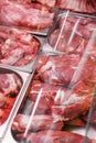 Heap of fresh meat food meat food background in supermarket store. Different types of raw meat in plastic boxes, leg of Royalty Free Stock Photo