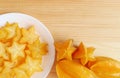Fresh Ripe Starfruit with a Plate of Mouthwatering Juicy Slices on Wooden Table