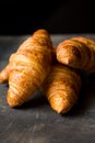 Heap of freshly baked croissants on black background, golden delicious crust,close up Royalty Free Stock Photo