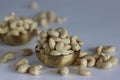 A heap of golden roasted cashews in a brass bowl