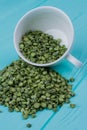 Heap of green split peas out of a cup. Royalty Free Stock Photo