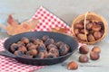 Heap of grilled edible chestnuts in cast iron skillet with textile napkin Royalty Free Stock Photo