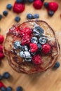 A heap of healthy vegan gluten free whole grain pancakes made with buckwheat flour topped with raspberries and blueberries Royalty Free Stock Photo