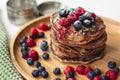 A heap of healthy vegan gluten free whole grain pancakes made with buckwheat flour topped with raspberries and blueberries Royalty Free Stock Photo