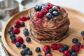 A heap of healthy vegan gluten free whole grain pancakes made with buckwheat flour topped with raspberries and blueberries Royalty Free Stock Photo