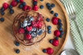 A heap of healthy vegan gluten free whole grain pancakes made with buckwheat flour topped with raspberries and blueberries Royalty Free Stock Photo