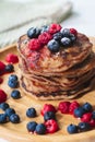 A heap of healthy vegan gluten free whole grain pancakes made with buckwheat flour topped with raspberries and blueberries Royalty Free Stock Photo