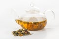 A heap of herbal tea and a glass teapot with brewing tisane Royalty Free Stock Photo