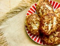 Heap of homemade delicious scrumptious ground meat burgers on striped plate on wooden table. Country style