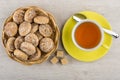 Heap of honey-cake in wicker basket, cup of tea