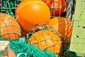 A heap, a huddle of traditional fishing equipement with green nets and orange buoys