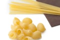 Heap of italian macaroni shells and spaghetti on brown napkin