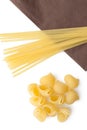 Heap of italian macaroni shells and spaghetti/pasta on napkin.
