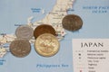 Heap of Japanese Yen coin money put on the Japan map. Concept of finance or travel