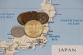 Heap of Japanese Yen coin money put on the Japan map. Concept of finance or travel