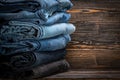 Heap of jeand. a bunch of pants. stack of different jeans on wooden background