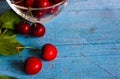A heap and a large glass bowl of fresh red ripe cherries and green leaves of a cherry tree Royalty Free Stock Photo