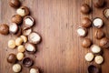 Heap of macadamia nuts on wooden table top view.