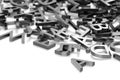 Heap of metal alphabetic character letters over white background, literature, education, know-how or writing concept, selective