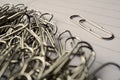 Heap of metal paper clips on white lined paper notepad as a symbol of typical office environment Royalty Free Stock Photo
