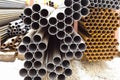 Heap of metal pipes in outdoor warehouse