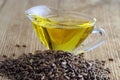 Heap of milk thistle seeds against a background of thistle oil in a glass gravy boat Royalty Free Stock Photo