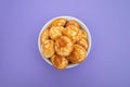 Heap of mini cereal pancakes in bowl on bright background.