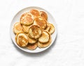 Heap of mini pancakes on a light background. Delicious breakfast, brunch, dessert. Baby food