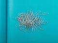 Heap of note paper clips on blue background top view