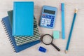 Heap of notepads, calculator and other stationery tools on table Royalty Free Stock Photo