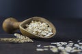 Heap of oat flakes in wooden shovel on rustic table