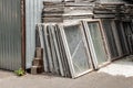 Heap of old wooden window frames with glass outdoors. Broken materials after window energy saving technology upgrade Royalty Free Stock Photo