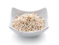 Heap of pearl barley in small bowl on white background