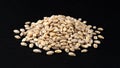 Heap of pearl barley grains on black background