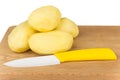 Heap of peeled raw potatoes and ceramic knife Royalty Free Stock Photo