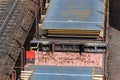 Heap pile heavy raw rusted steel iron sheet plates loaded on railroad cargo freight carriage. Metal goods factory plant