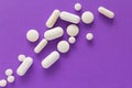 Heap of pills spreaded over color table. Group of assorted white Royalty Free Stock Photo