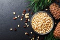 Heap of pine nuts and cedar cones on black table top view. Organic and healthy superfood. Royalty Free Stock Photo